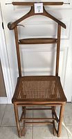 Front view of antique Italian valet chair showing cane seat, wooden hanger, and small accessory tray.
