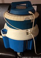 Blue and beige Kenmore Power Spray carpet cleaner with attached hose and power cord.