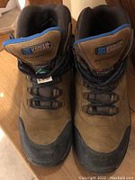 Front view of the pair of brown Kodiak waterproof steel toe work boots with black rubber toe caps and blue lining.