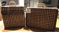 Two closed wicker picnic baskets side by side on a table