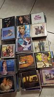 Collection of music CDs stacked, showing covers of artists like Billy Vaughn, Olivia Newton-John, Govi, Tim Janis