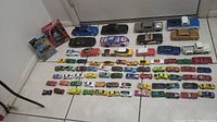 Photo of 75 die cast cars arranged on floor, showing multiple colors and styles.