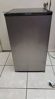 Front view of compact Frigidaire refrigerator on tile floor showing minor surface wear.