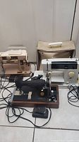 Lot showing three vintage sewing machines together including Singer 401a beige, black Singer 1940s model, and white J.C. Penney 344c with carrying case.