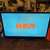 Front view of the powered-on RCA television displaying the RCA logo on the screen.