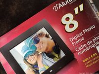 Photo of the front of the box showing brand, model size (8 inch), digital photo frame image, and resolution 800x600.