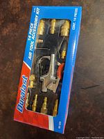 Boxed Duralast air tool accessory kit showing clear view of various brass fittings and metal air blow gun inside packaging
