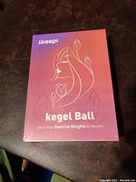 Front view of the Ikeepi Kegel Ball kit box with gradient pink-purple color and white graphic illustration of woman’s face and tulips, labeled Kegel Ball Pelvic Floor Exercise Weights for Women.