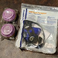 Blue half mask respirator in original sealed packaging with label, showing brand name, size small, and product series 2000.