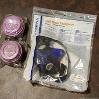 Sperian Series 2000 Half Mask Respirator in original packaging showing the blue facepiece and two sealed pink round filters.