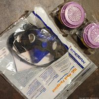 Sperian Series 2000 half mask respirator facepiece in original packaging along with two sealed replacement filters.