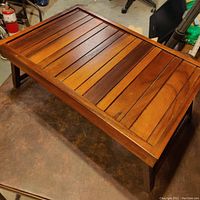 View of the top surface showing the slatted wood construction with a polished finish.