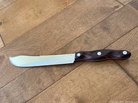 Full view of the butcher knife showing the blade and brown handle.