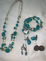 Full lot showing necklace, bracelet, and three pairs of pierced earrings with blue stones and silver-tone accents on white background.