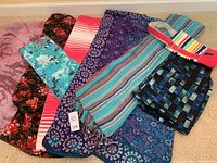 Overview of ladies scarves with varied patterns: floral, striped, paisley, geometric, in varied hues. Also includes Lands' End summer wine carry bag with checkered blue/black design and red handle.