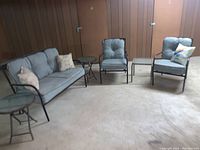 Full view of patio set showing loveseat, two chairs, cushions, and side tables.