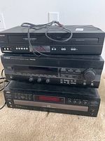 Stacked Yamaha stereo receiver RX-V293, Philips VCR, JVC 5-CD changer XL-FZ158 showing lot items.