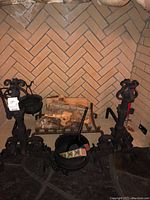 Overview of two steel stands with hanging cauldrons and small shovel