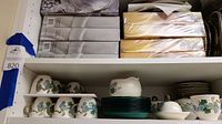 Shelves with tea cups, saucers, serving trays, and butter dish from Poppytrail by Metlox collection