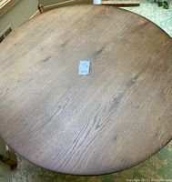Top view of round wooden dining table showing surface texture and natural wood grain with knots.