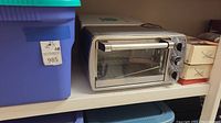 Oster toaster oven and blue storage bin on shelf