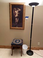 Photo showing the framed print, floor lamp, vintage stool and plastic waste basket together