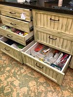 Open kitchen drawers showing assorted kitchen items stored inside including packets, utensils, and various kitchen accessories.