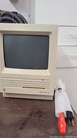 Front view of Macintosh SE computer with power cable