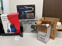 Multiple boxed items including heat gun, rotary tool kit, submersible pump and miscellaneous parts boxes.