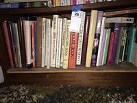 Shelf of various interior design and decorating books, showing assorted titles and visible wear and dust.