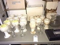 Overview of the stemware set including wrapped small and large wine glasses, a glass pitcher, and boxes.