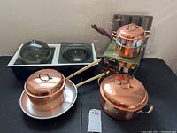 Copper pots with lids, stainless steel pan, and boxed fondue pot with serving trays with glass lids