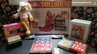 Photo of the full lot including boxed dollhouse, plush bear, china set, and games.