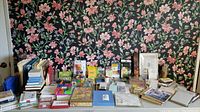 Full view of all office supplies including notebooks, folders, note cards, and craft items on a table against a floral wallpaper background