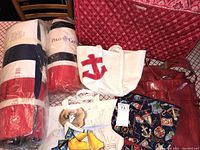 Full lot showing all bags: beach mat, towels, white tote with red anchor, nautical themed smaller tote, and large red quilted rolling garment bag.