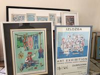 Group of all framed wall art pieces and small tile against wall
