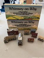 Photo of porcelain miniature English village sets arranged with original boxes visible in background