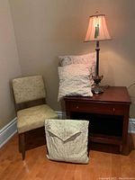 Boudoir chair, lamp, and pillows arranged together in corner