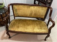 Front view of wood frame settee with gold upholstery
