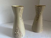 Photo showing both small midcentury tan ceramic vases with brown linear patterns and raised colored drops.