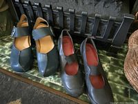 Three pairs of women's shoes including blue Fluevog heels and two pairs of Camper shoes in black leather.
