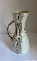 Front view of the vase showing the handle and detailed vertical gold and green crackle pattern.