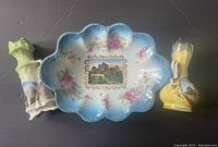 Front view of three souvenir items including two bud vases and one large scalloped dish featuring Toronto landmarks