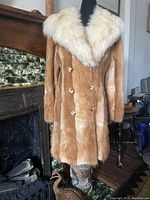 Front view of vintage fox fur jacket on mannequin, showing double breasted button closure with white shawl collar.