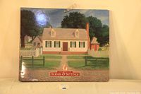 Closed book showing front cover image of a colonial house with white picket fence and large trees.