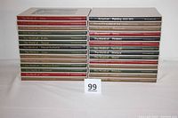 Front view of the 28 Time-Life Library of Art books stacked in two piles, showing spine titles and overall condition.