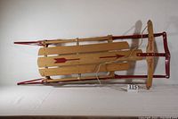 Top view of full sled showing wooden slats and red metal frame with rope attached