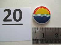 Front view of the round Earth Day 1970 pin showing the sun and water design with measurement ruler and lot number card