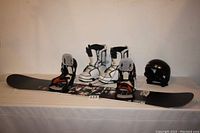 Snowboard, boots, and helmet displayed side-by-side showing overall lot contents