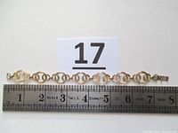Full bracelet stretched straight with measuring ruler below showing approximately 7 inches long.